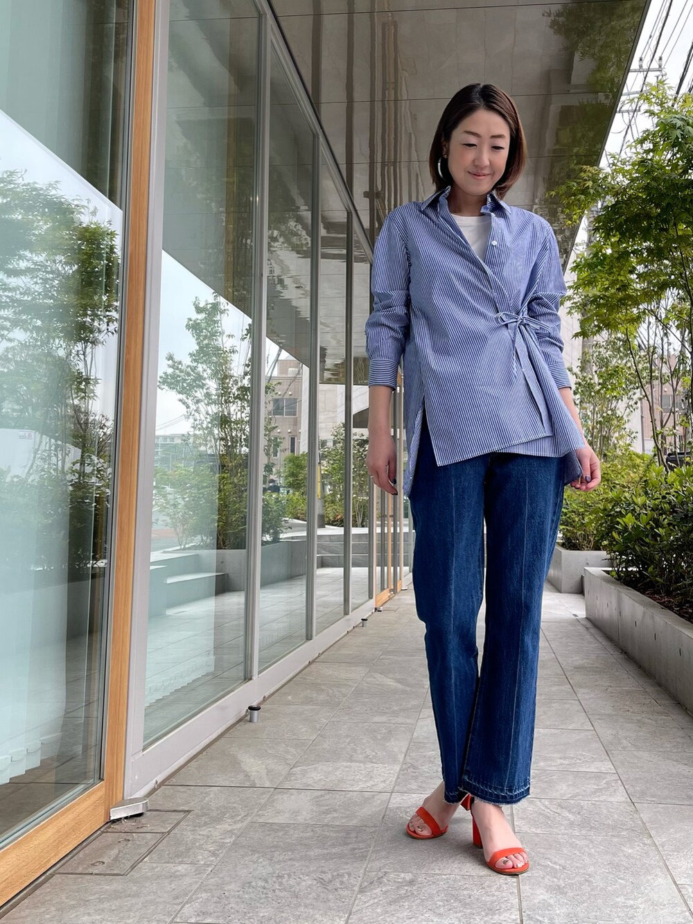 ブルー系のシャツ/ブラウス、ブルー系のデニムパンツ、ホワイト系のTシャツ/カットソーを着用したレディースの春コーディネートの3枚目の写真