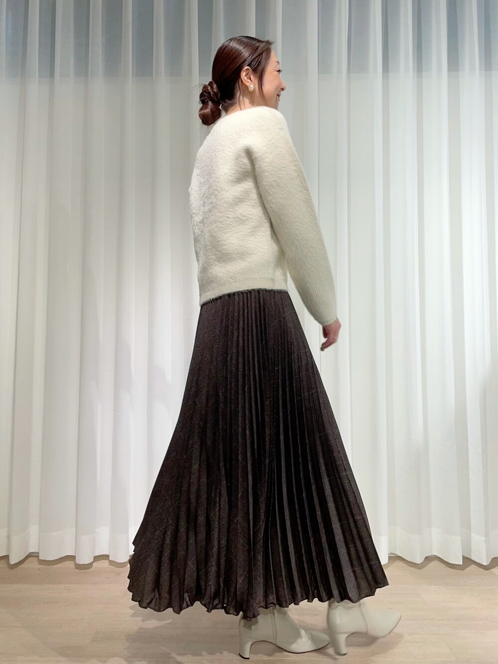 ホワイト系のニット/セーター、ブラウン系のスカート、ホワイト系のニット/セーターを着用したレディースの秋コーディネートの2枚目の写真