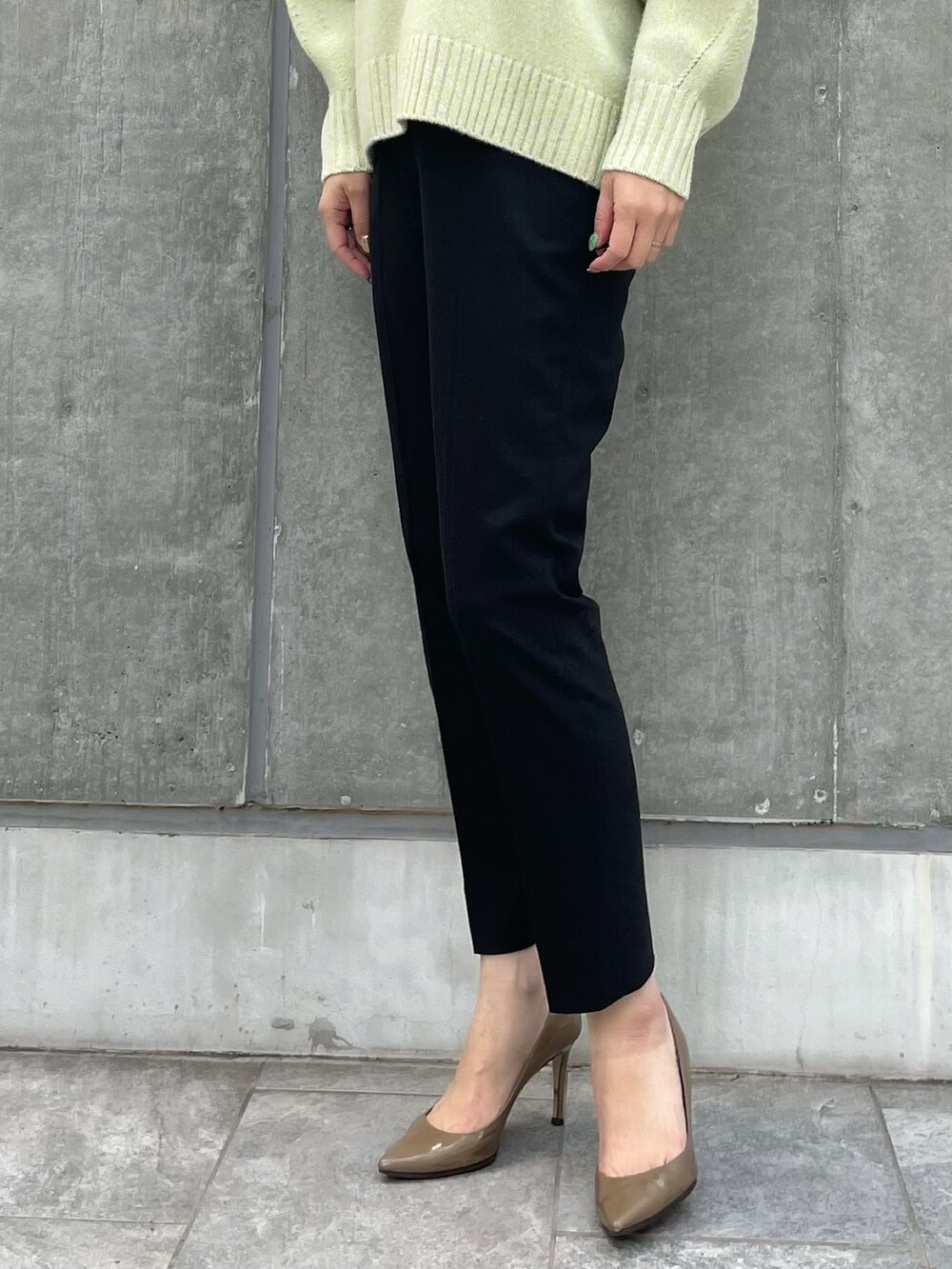 イエロー系のニット/セーター、ブラック系のパンツ、イエロー系のニット/セーターを着用したレディースの冬コーディネートの2枚目の写真