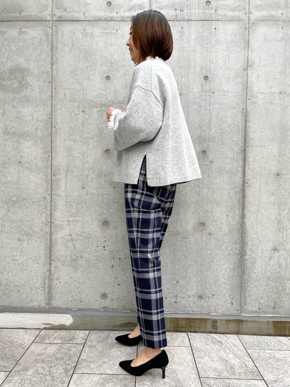 グレー系のニット/セーター、その他のパンツ、ホワイト系のシャツ/ブラウスを着用したレディースの冬コーディネートの3枚目の写真