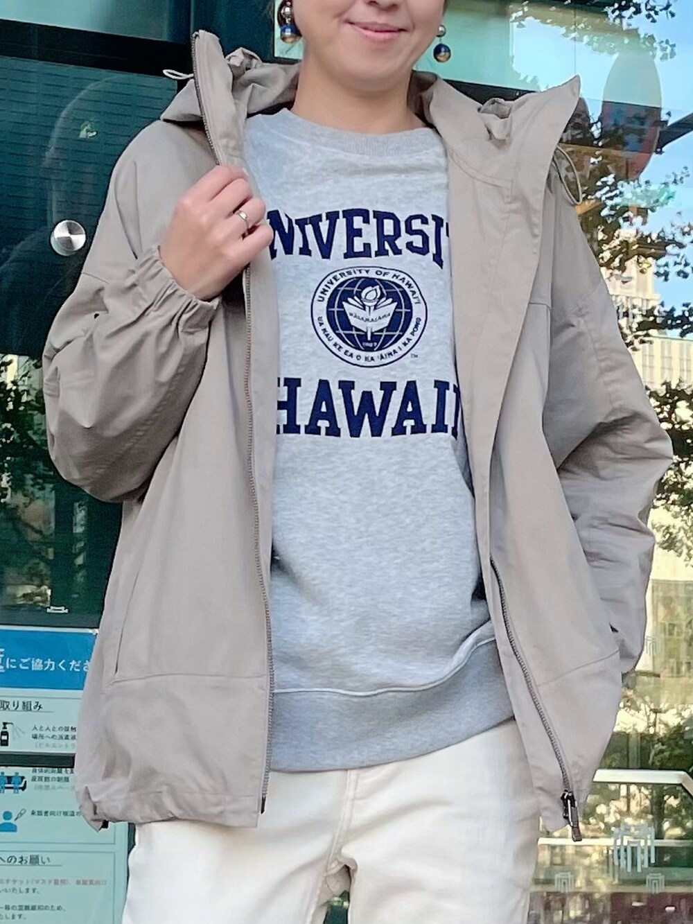 ベージュ系のマウンテンパーカー、グレー系のスウェット、ホワイト系のデニムパンツを着用したレディースの秋コーディネートの3枚目の写真