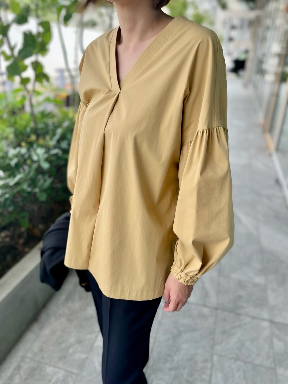 ベージュ系のシャツ/ブラウス、ブラック系のパンツ、ブラック系のカーディガン/ボレロを着用したレディースの秋コーディネートの4枚目の写真