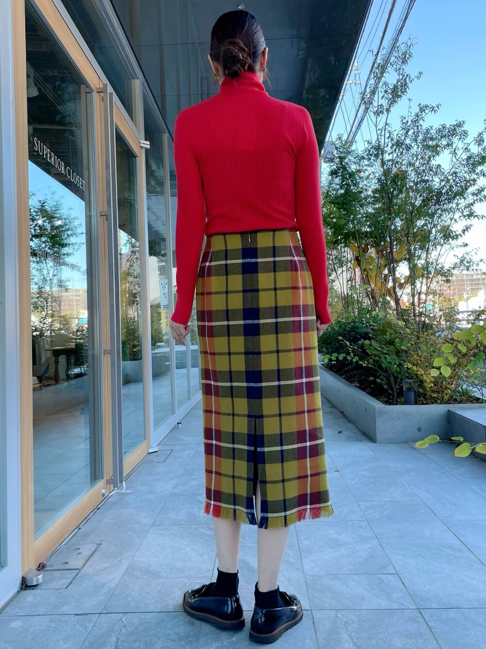 レッド系のニット/セーター、イエロー系のスカート、レッド系のニット/セーターを着用したレディースの冬コーディネートの3枚目の写真