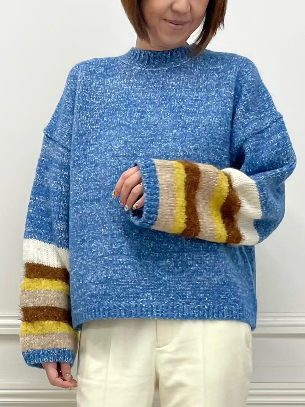 ブルー系のニット/セーター、ホワイト系のパンツ、ブルー系のニット/セーターを着用したレディースの冬コーディネートの4枚目の写真