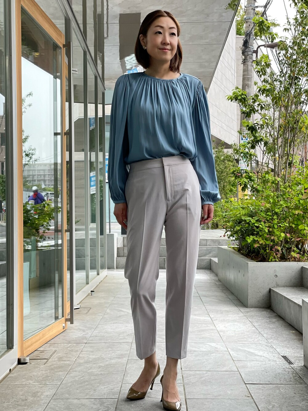 グレー系のテーラードジャケット、グレー系のパンツ、ブルー系のシャツ/ブラウスを着用したレディースの春コーディネートの2枚目の写真