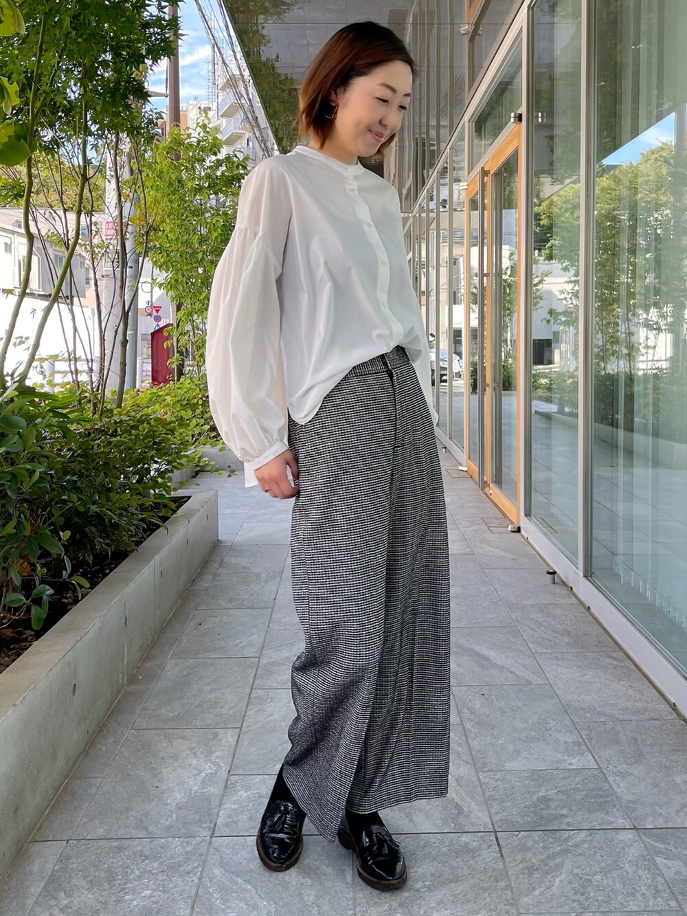 ホワイト系のシャツ/ブラウス、ブラック系のパンツを着用したレディースの秋コーディネートの2枚目の写真