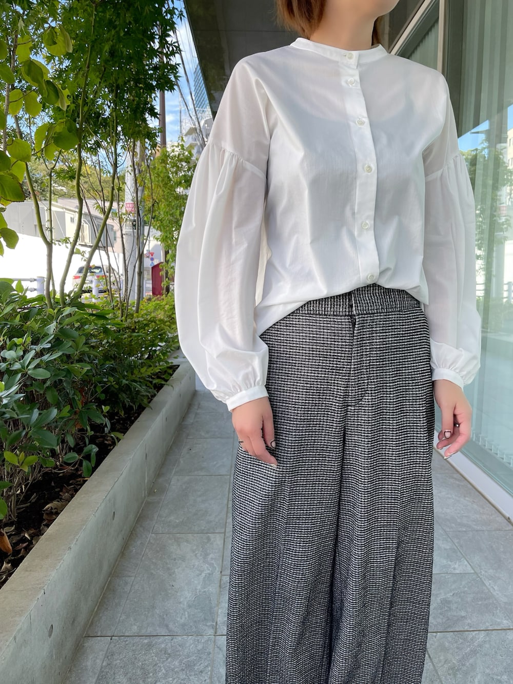 ホワイト系のシャツ/ブラウス、ブラック系のパンツを着用したレディースの秋コーディネートの4枚目の写真