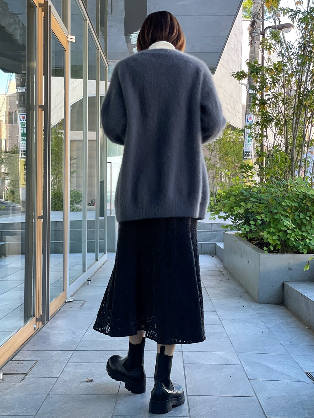 ブラウン系のカーディガン/ボレロ、ホワイト系のニット/セーター、ブラック系のスカートを着用したレディースの秋コーディネートの4枚目の写真