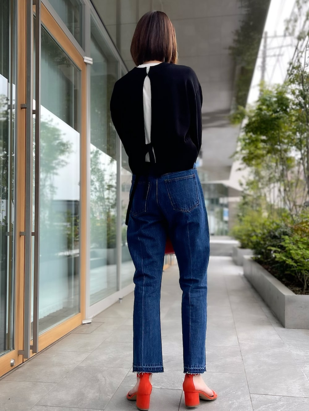 ブラック系のカーディガン/ボレロ、ブルー系のデニムパンツ、ホワイト系のTシャツ/カットソーを着用したレディースの春コーディネートの3枚目の写真