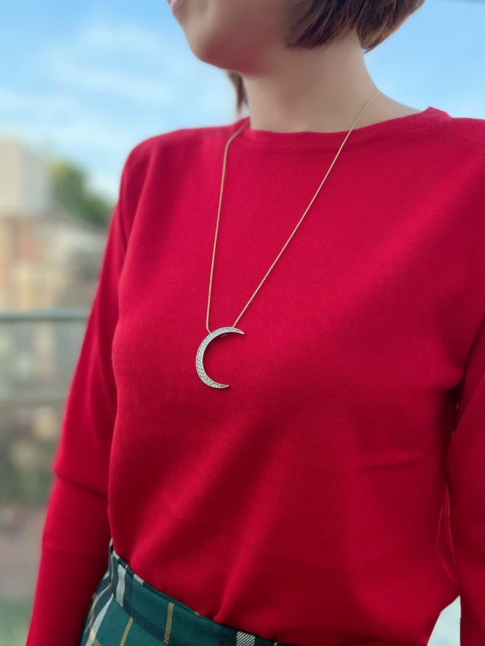 レッド系のニット/セーター、グリーン系のスカート、レッド系のニット/セーターを着用したレディースの秋コーディネートの3枚目の写真