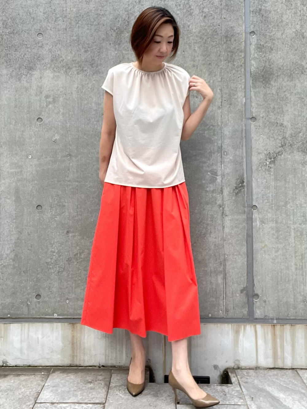 ベージュ系のTシャツ/カットソー、レッド系のスカート、レッド系のスカートを着用したレディースの夏コーディネートの4枚目の写真