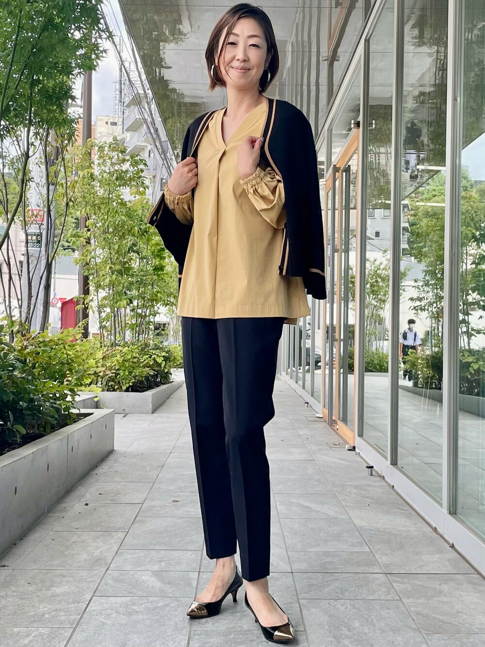 ベージュ系のシャツ/ブラウス、ブラック系のパンツ、ブラック系のカーディガン/ボレロを着用したレディースの秋コーディネートの5枚目の写真