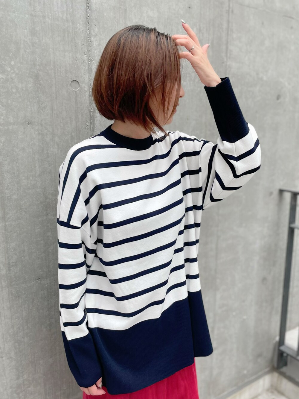 ホワイト系のニット/セーター、レッド系のスカート、その他のニット/セーターを着用したレディースの秋コーディネートの3枚目の写真