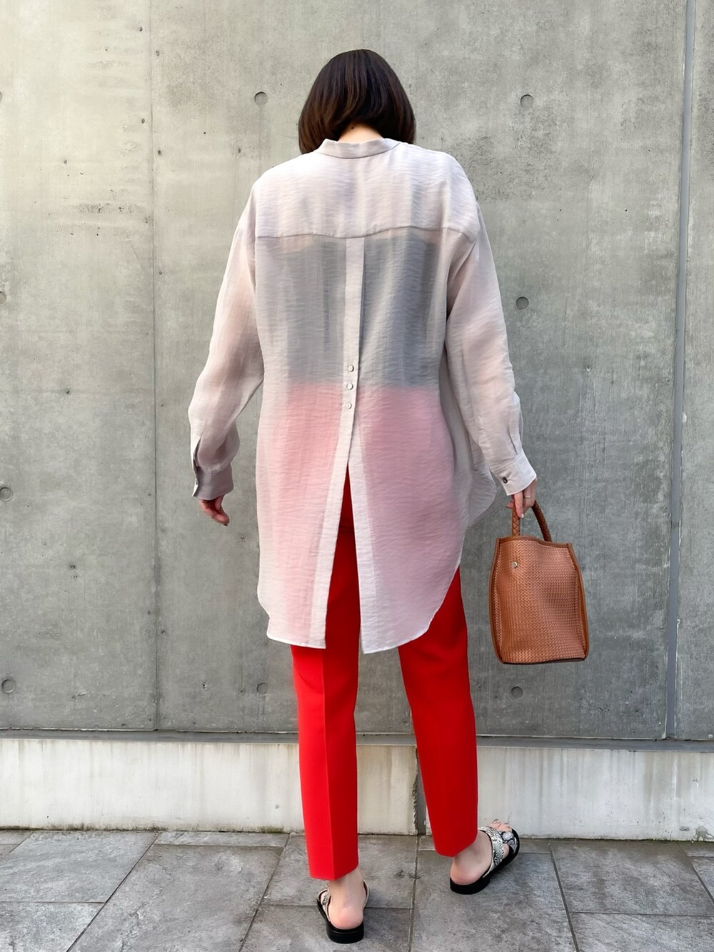 グレー系のシャツ/ブラウス、レッド系のパンツ、ブラウン系のバッグを着用したレディースの春コーディネートの2枚目の写真