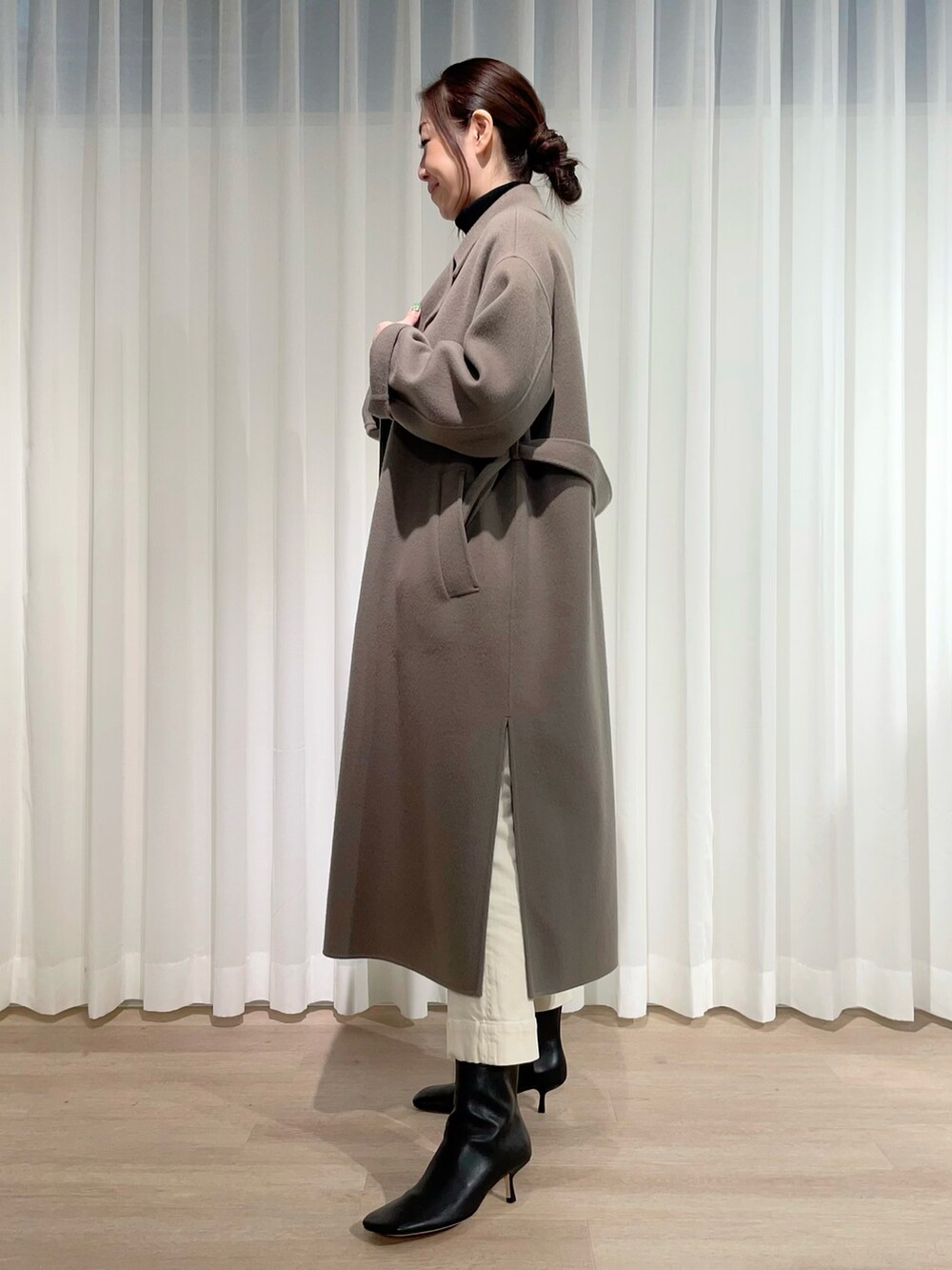 ブラック系のニット/セーター、ホワイト系のデニムパンツ、グリーン系のジャケット/アウターを着用したレディースの冬コーディネートの2枚目の写真