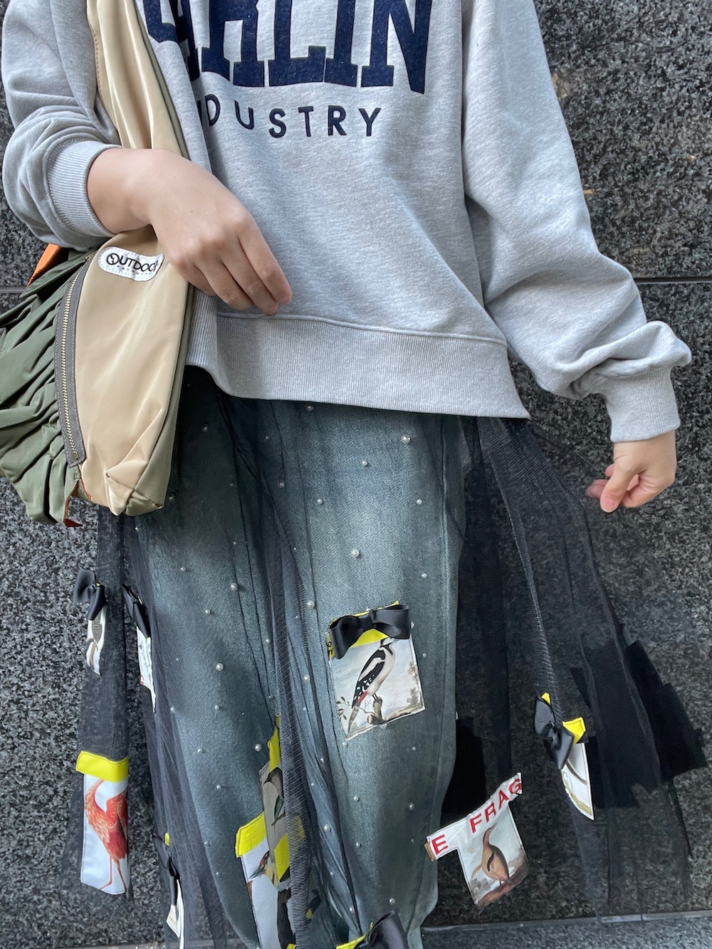 グレー系のスウェット、ブルー系のデニムパンツ、グリーン系のトートバッグを着用したレディースの冬コーディネートの8枚目の写真