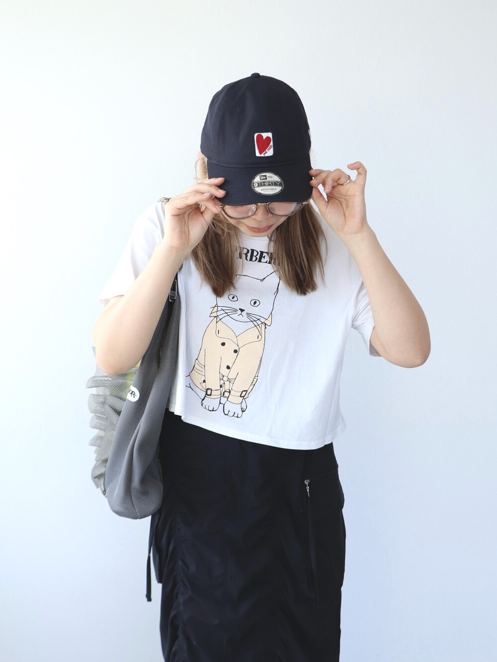 ブラック系のスカート、グレー系のトートバッグ、ホワイト系のTシャツ/カットソーを着用したレディースの春コーディネートの8枚目の写真
