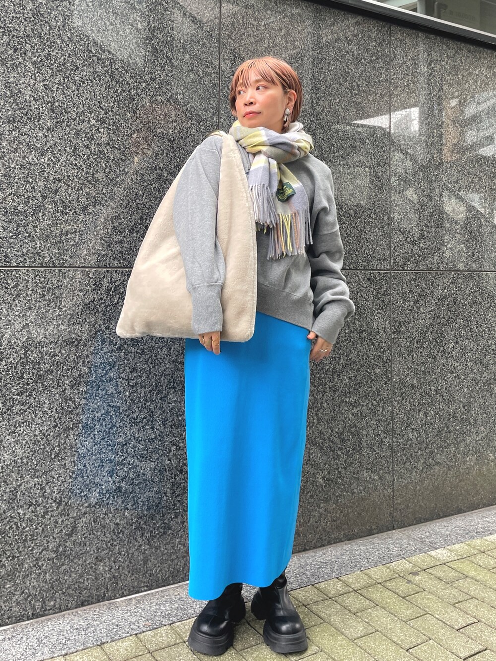 ブルー系のスカート、グレー系のスウェット、ホワイト系のパーカーを着用したレディースの秋コーディネートの3枚目の写真