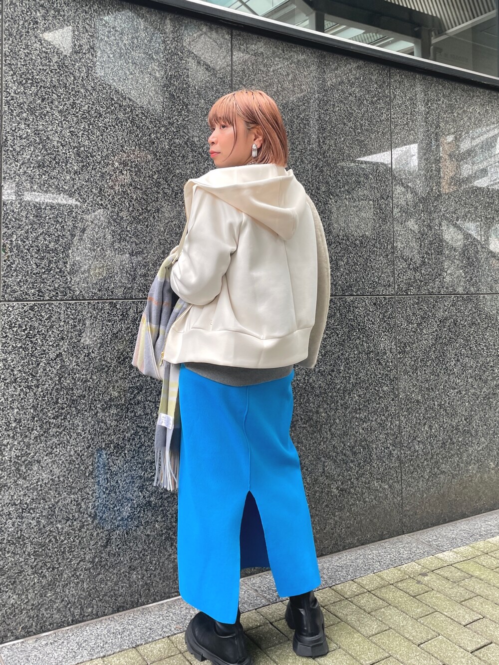 ブルー系のスカート、グレー系のスウェット、ホワイト系のパーカーを着用したレディースの秋コーディネートの2枚目の写真