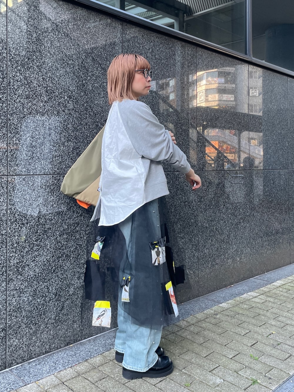 グレー系のスウェット、ブルー系のデニムパンツ、グリーン系のトートバッグを着用したレディースの冬コーディネートの6枚目の写真