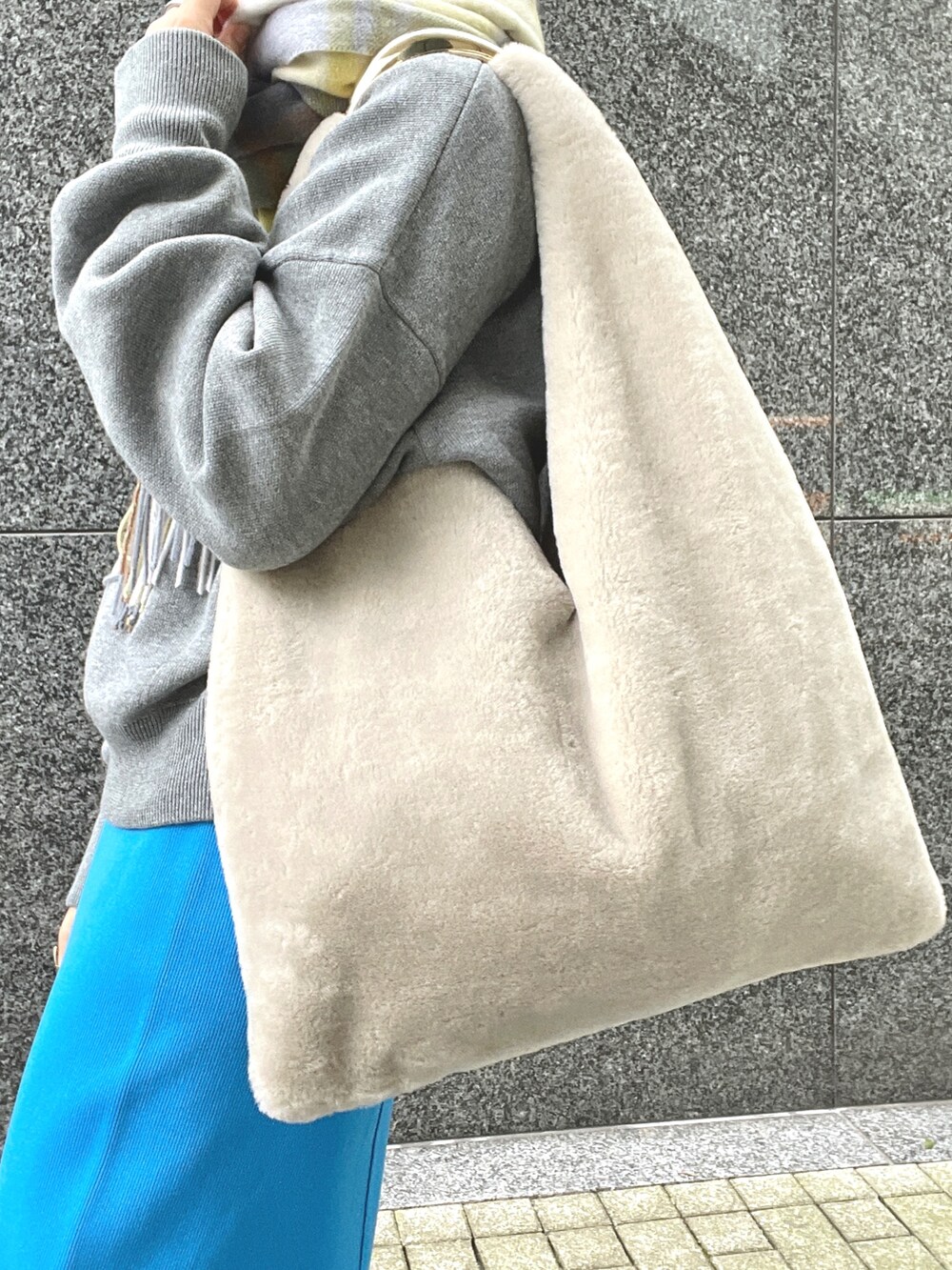 ブルー系のスカート、グレー系のスウェット、ホワイト系のパーカーを着用したレディースの秋コーディネートの5枚目の写真