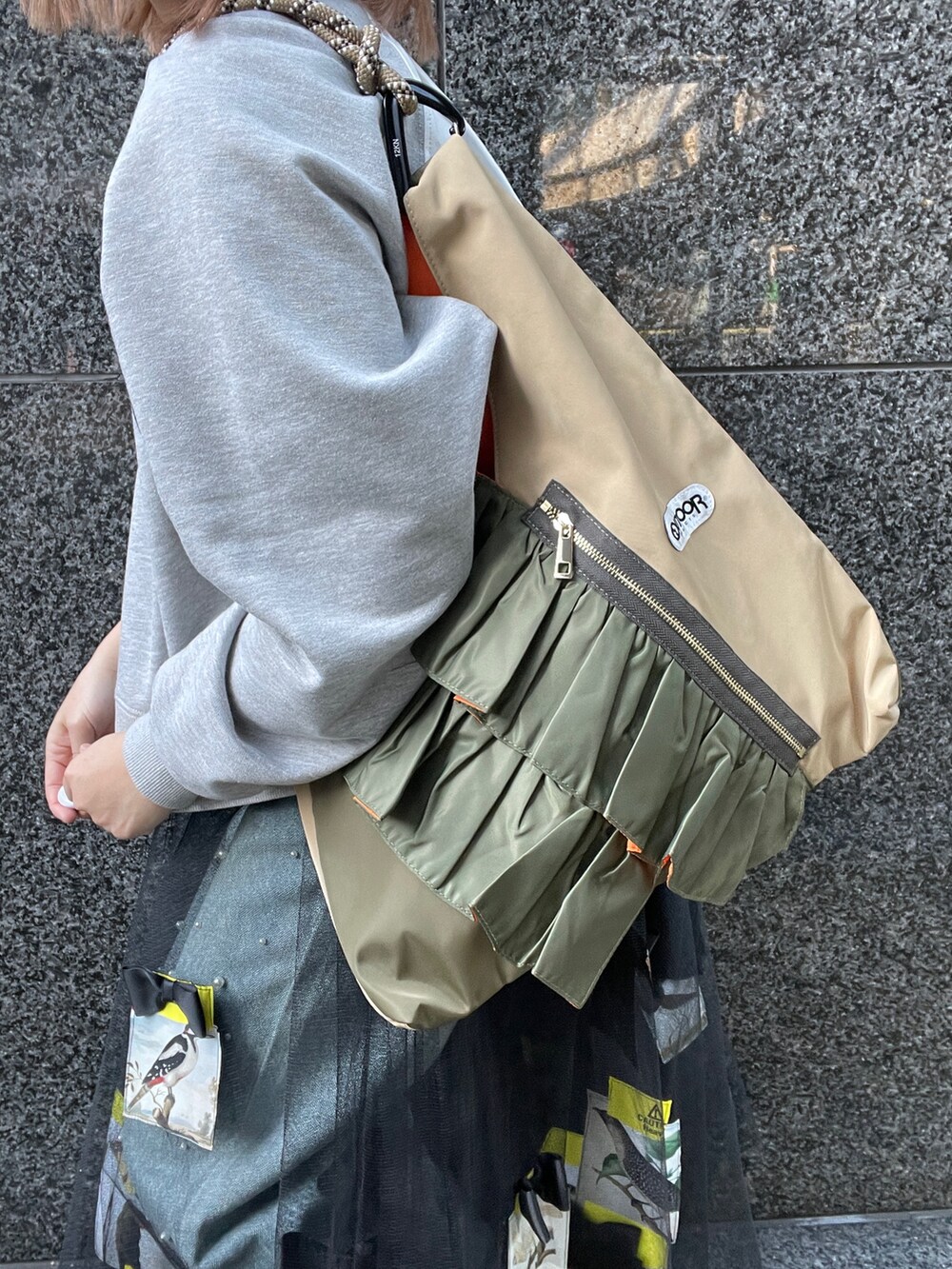 グレー系のスウェット、ブルー系のデニムパンツ、グリーン系のトートバッグを着用したレディースの冬コーディネートの7枚目の写真