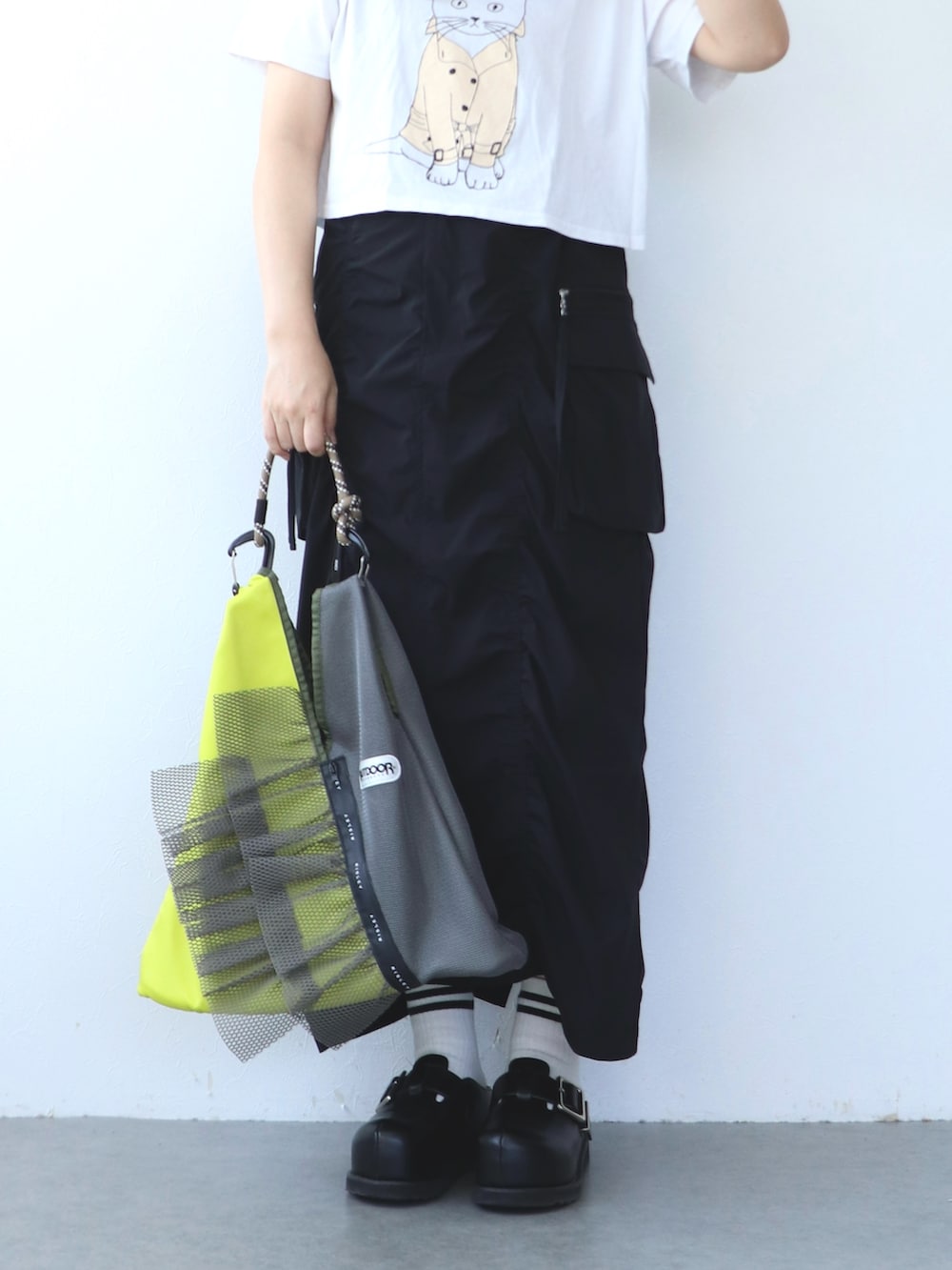 ブラック系のスカート、グレー系のトートバッグ、ホワイト系のTシャツ/カットソーを着用したレディースの春コーディネートの7枚目の写真