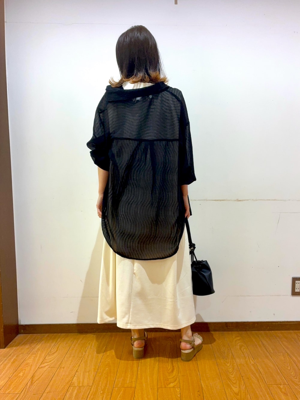 ベージュ系のサンダル、ブラック系のショルダーバッグ、ホワイト系のワンピースを着用したレディースの春コーディネートの3枚目の写真