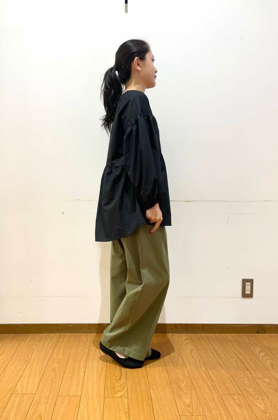 ホワイト系のショルダーバッグ、ブラック系のシャツ/ブラウス、グリーン系のチノパンツを着用したレディースの夏コーディネートの3枚目の写真