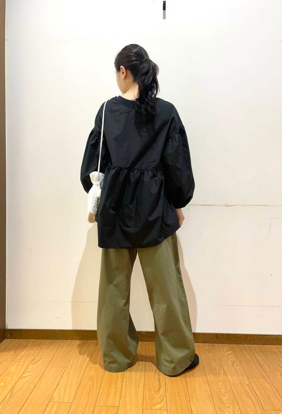 ホワイト系のショルダーバッグ、ブラック系のシャツ/ブラウス、グリーン系のチノパンツを着用したレディースの夏コーディネートの4枚目の写真