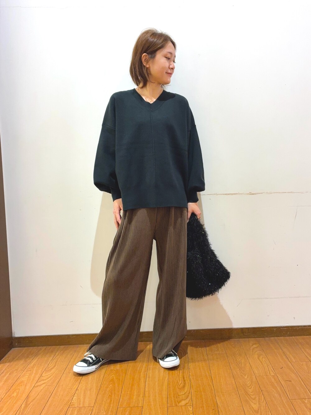 ブラック系のスニーカー、ブラック系のトートバッグ、ブラウン系のその他パンツを着用したレディースの秋コーディネートの4枚目の写真