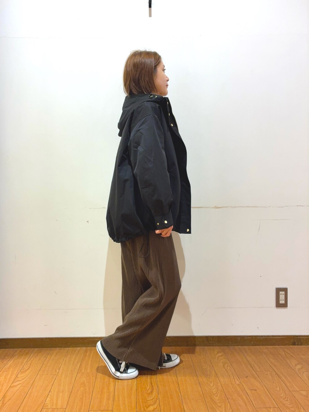 ブラック系のスニーカー、ブラック系のトートバッグ、ブラウン系のその他パンツを着用したレディースの秋コーディネートの2枚目の写真