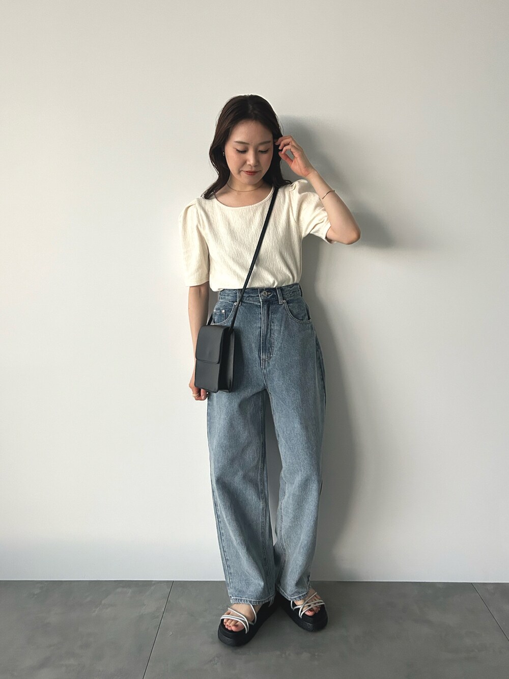 ブルー系のその他パンツ、ホワイト系のTシャツ/カットソー、ブラック系のハンドバッグを着用したレディースの夏コーディネートの2枚目の写真