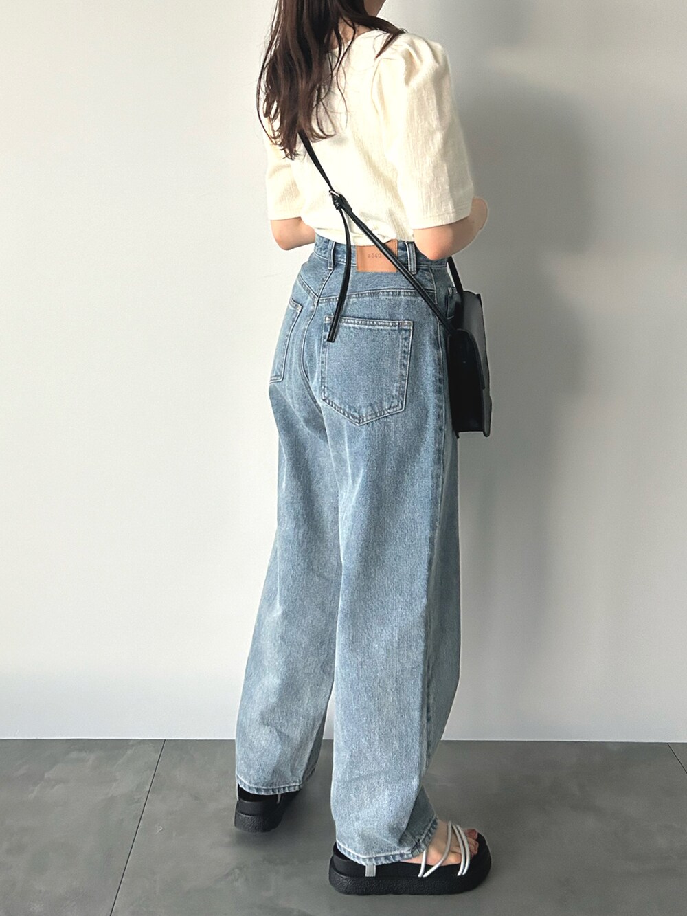 ブルー系のその他パンツ、ホワイト系のTシャツ/カットソー、ブラック系のハンドバッグを着用したレディースの夏コーディネートの3枚目の写真