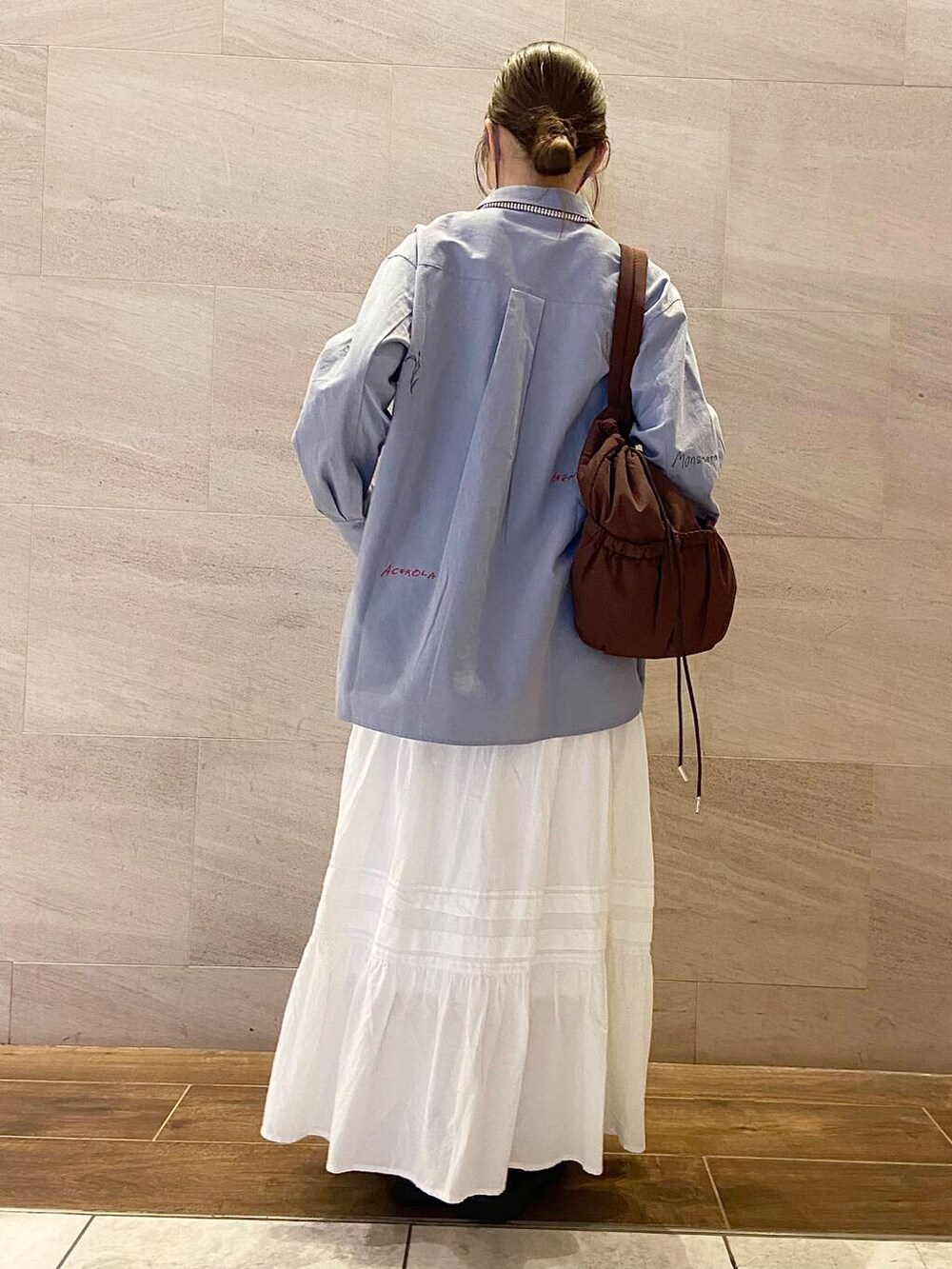 ブラウン系のローファー、ブラウン系のショルダーバッグ、ブルー系のシャツ/ブラウスを着用したレディースの冬コーディネートの4枚目の写真