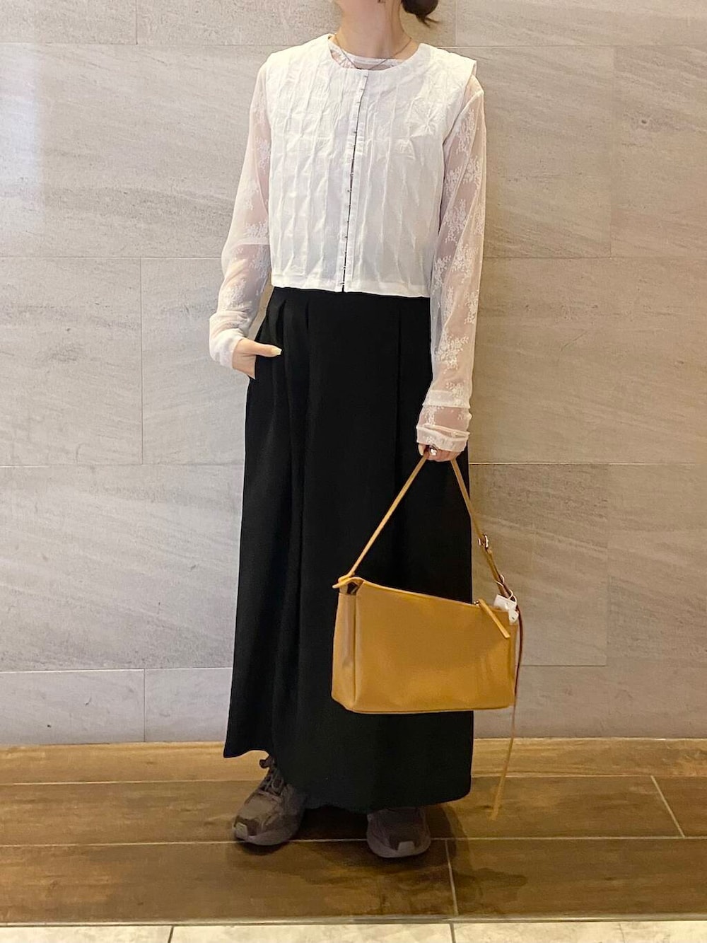 イエロー系のショルダーバッグ、ホワイト系のベスト、ホワイト系のTシャツ/カットソーを着用したレディースの春コーディネートの4枚目の写真