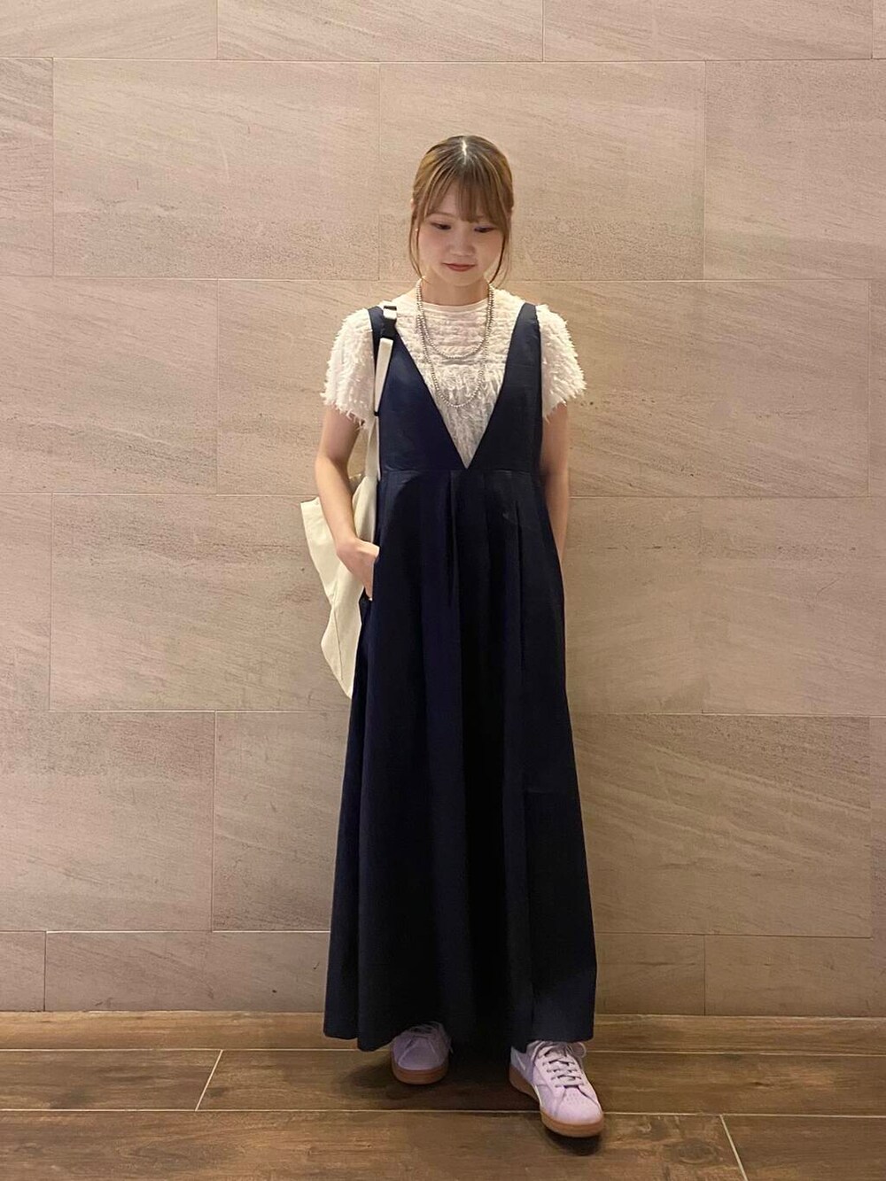 ホワイト系のショルダーバッグ、ブルー系のワンピース、パープル系のスニーカーを着用したレディースの夏コーディネートの2枚目の写真