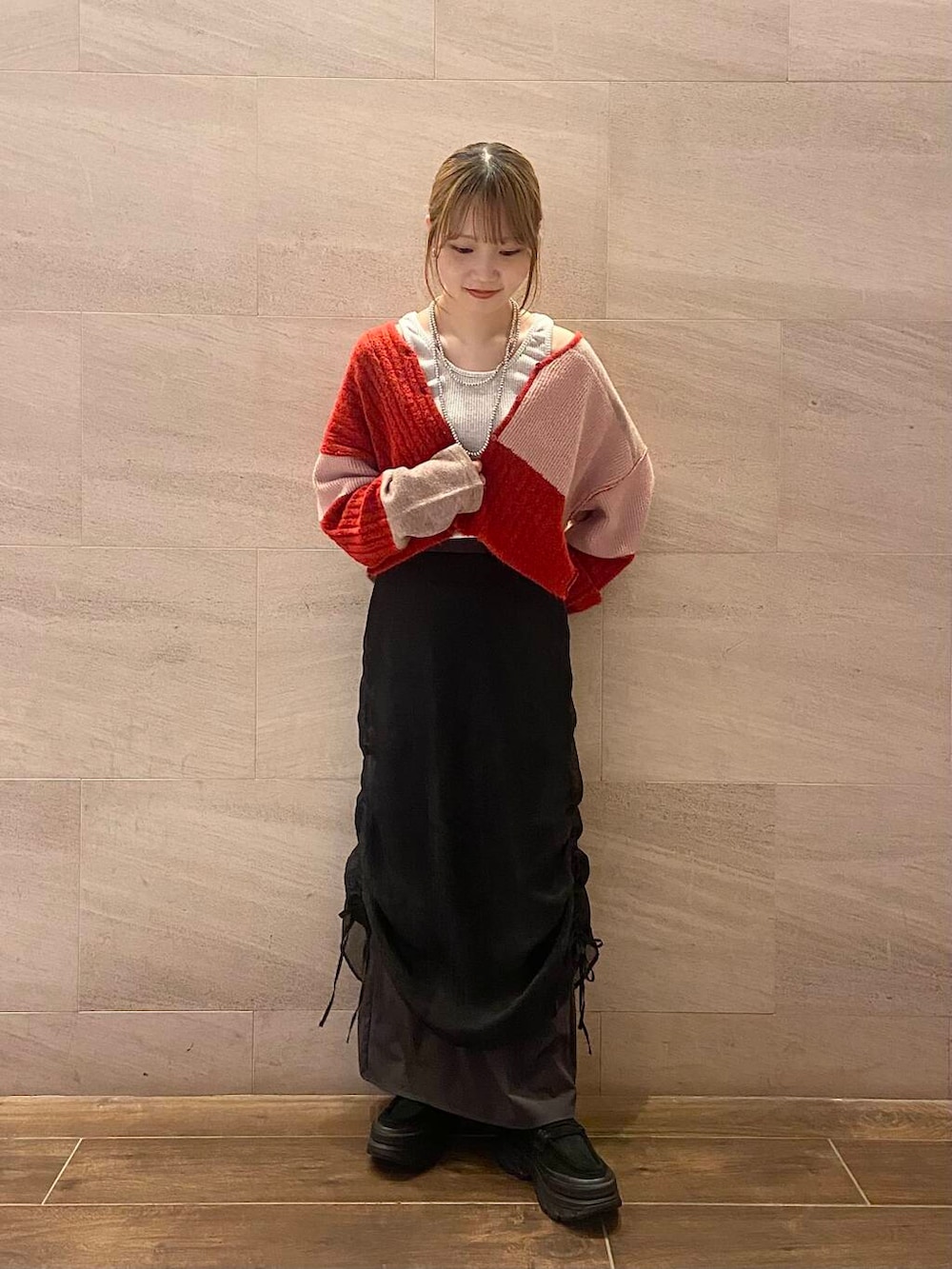 ブラック系のスカート、ブラック系のスニーカー、ベージュ系のタンクトップを着用したレディースの夏コーディネートの5枚目の写真