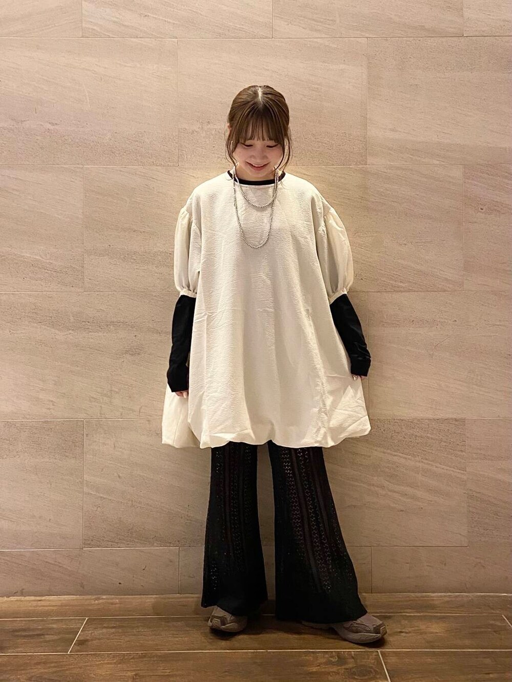 ブラック系のハンドバッグ、ブラック系のTシャツ/カットソー、ホワイト系のワンピースを着用したレディースの秋コーディネートの2枚目の写真