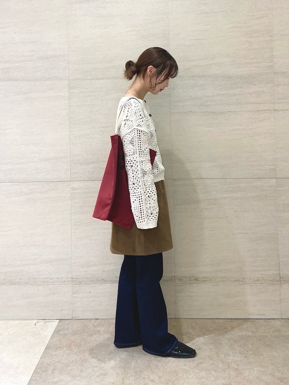 イエロー系のスカート、ベージュ系のカーディガン/ボレロ、レッド系のトートバッグを着用したレディースの秋コーディネートの3枚目の写真