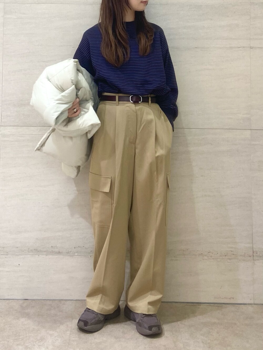 ホワイト系のダウンジャケット/コート、ブラウン系のニット/セーター、ベージュ系のその他パンツを着用したレディースの秋コーディネートの5枚目の写真