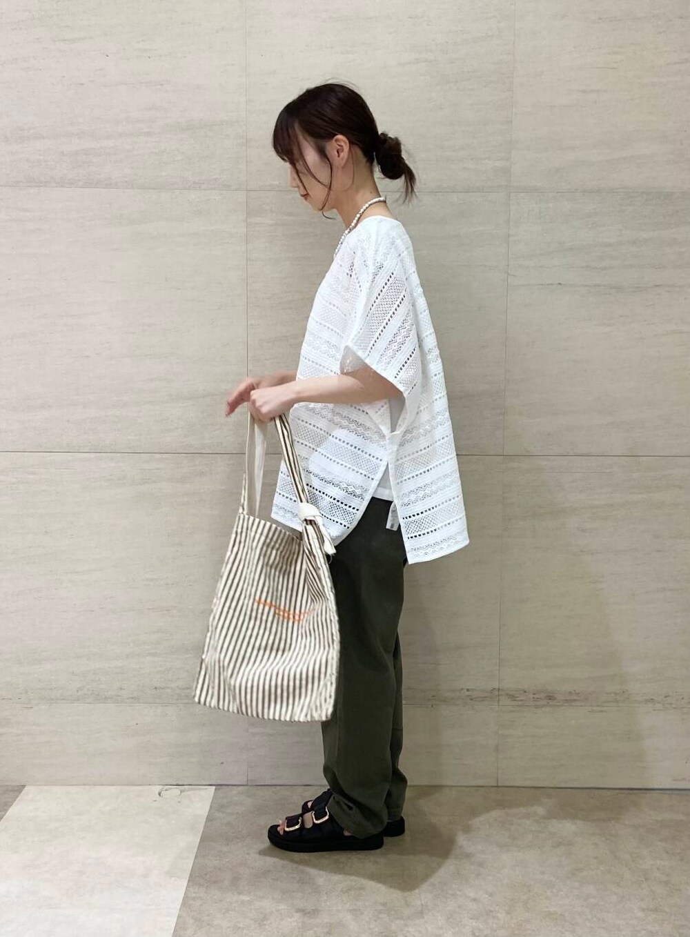 ブラウン系のエコバッグ/サブバッグ、グリーン系のその他パンツ、ブラック系のサンダルを着用したレディースの夏コーディネートの3枚目の写真