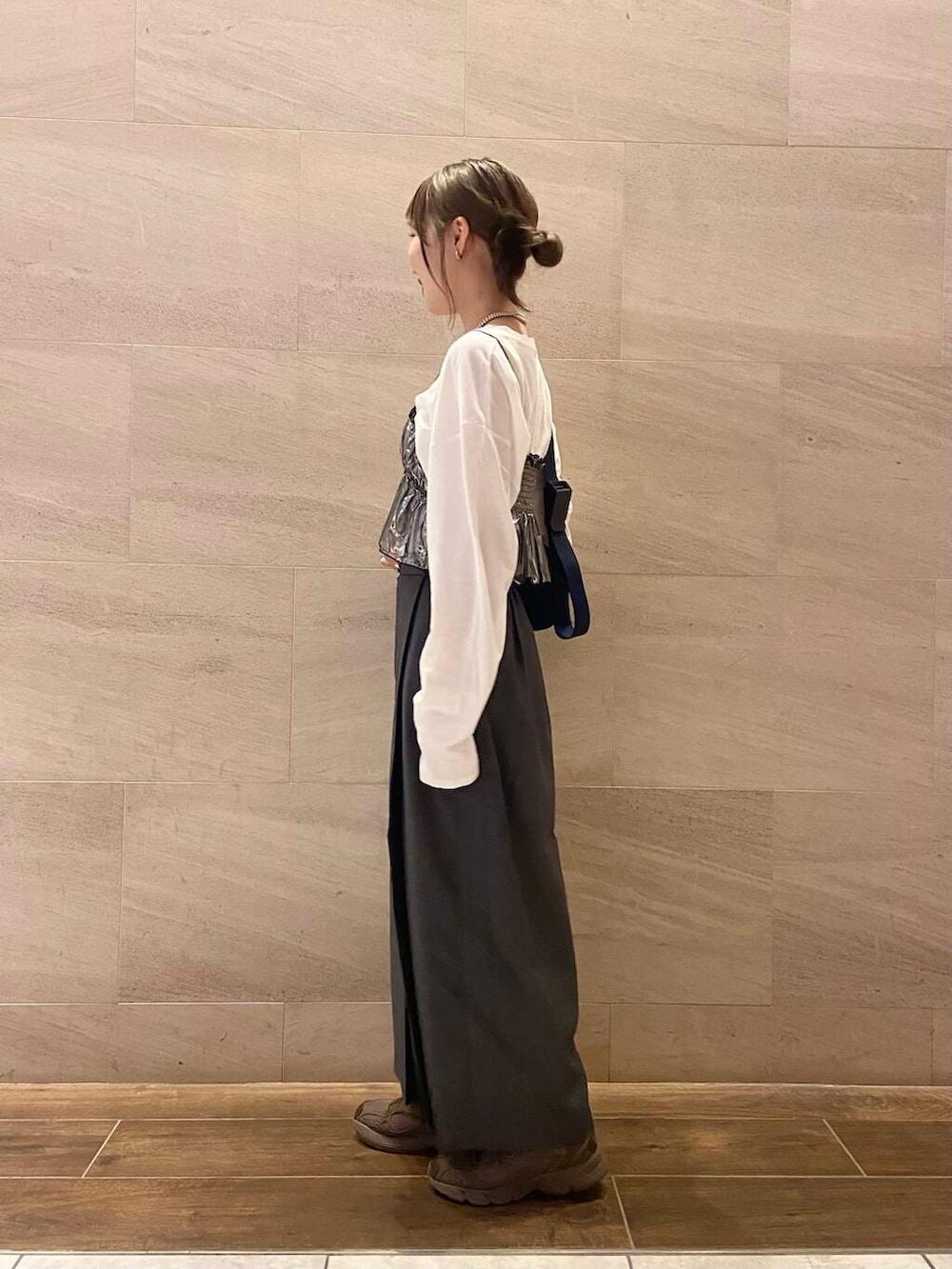 ブルー系のショルダーバッグ、グレー系のスカート、シルバー系のベストを着用したレディースの秋コーディネートの3枚目の写真