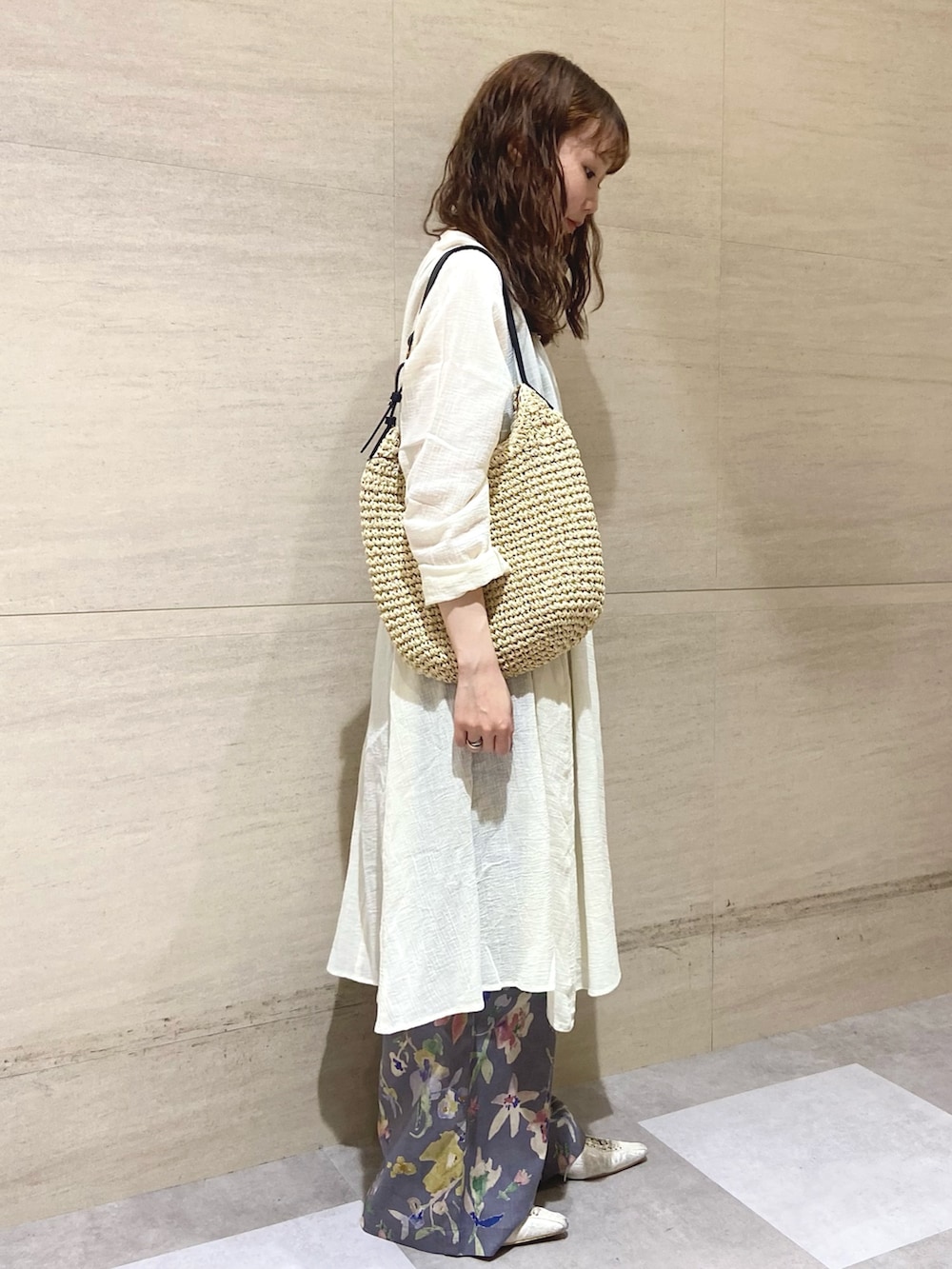 グレー系のその他パンツ、ホワイト系のチュニック、ベージュ系のトートバッグを着用したレディースの夏コーディネートの2枚目の写真