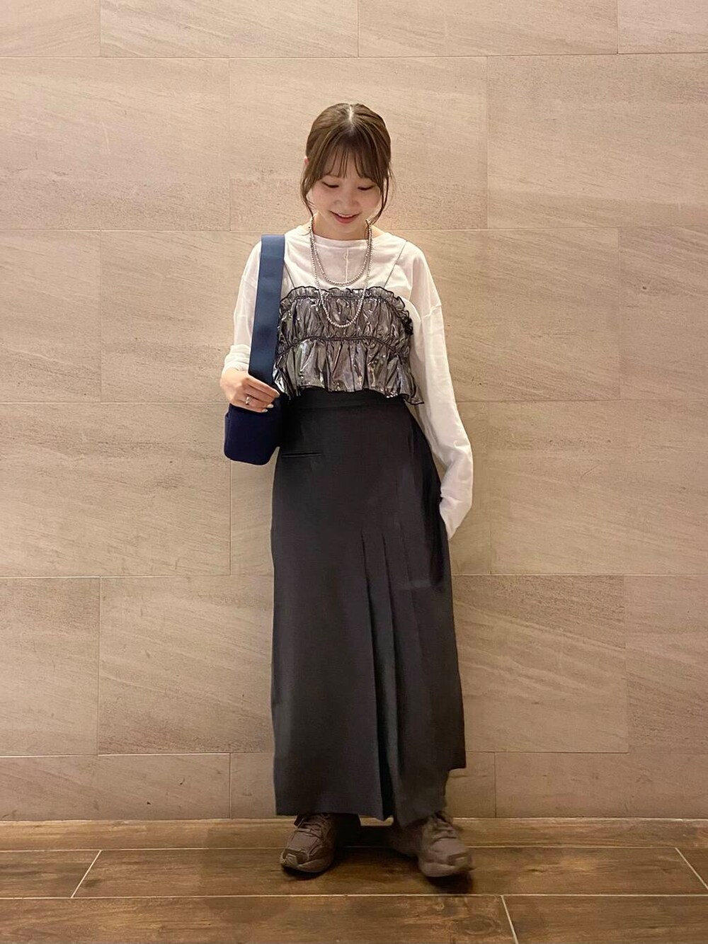 ブルー系のショルダーバッグ、グレー系のスカート、シルバー系のベストを着用したレディースの秋コーディネートの5枚目の写真