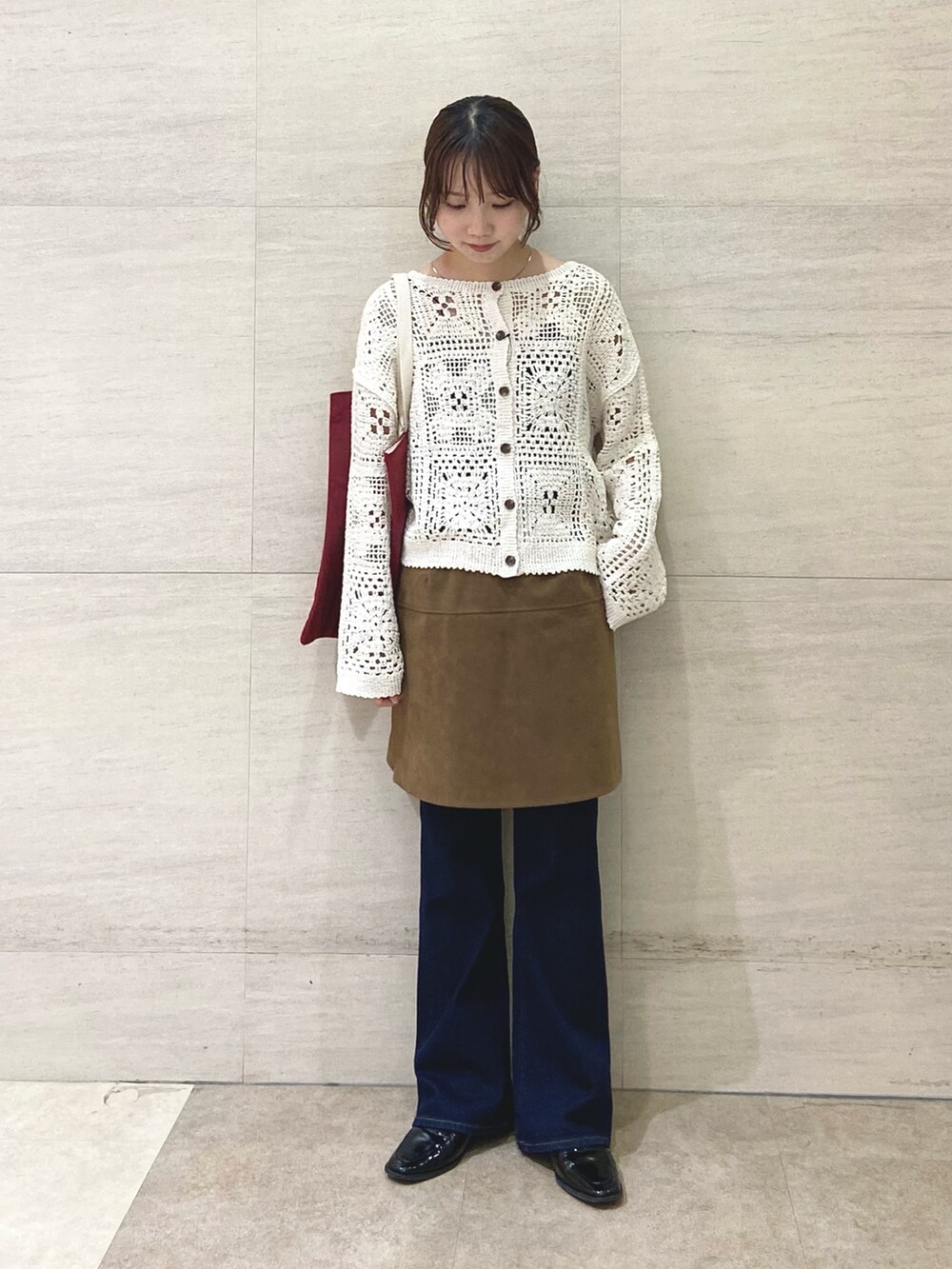 イエロー系のスカート、ベージュ系のカーディガン/ボレロ、レッド系のトートバッグを着用したレディースの秋コーディネートの5枚目の写真