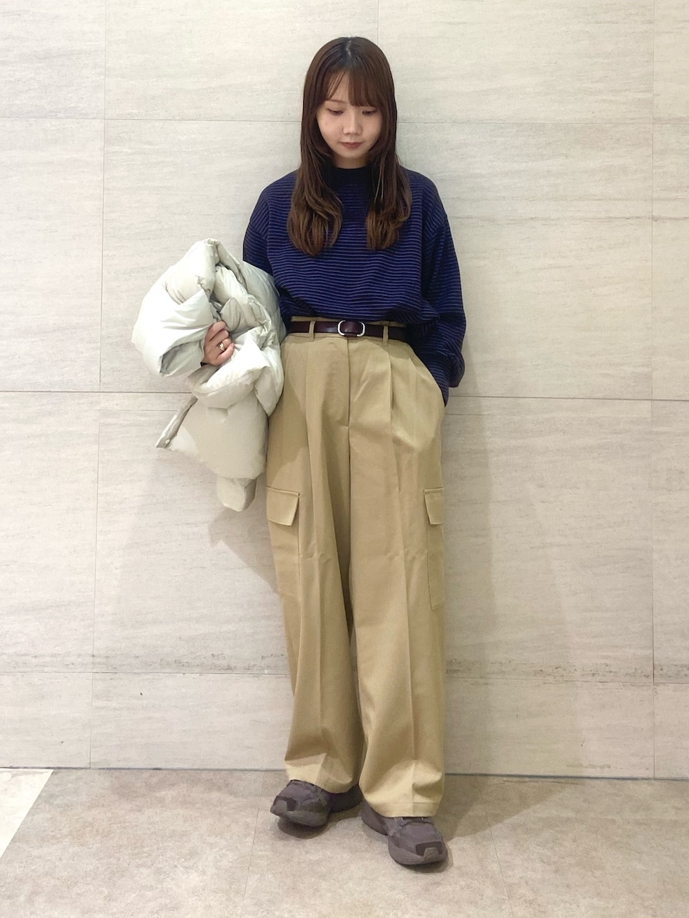 ホワイト系のダウンジャケット/コート、ブラウン系のニット/セーター、ベージュ系のその他パンツを着用したレディースの秋コーディネートの4枚目の写真