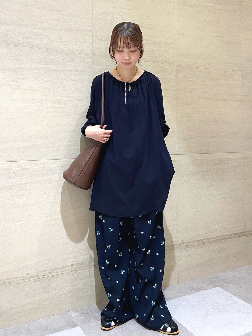 ブルー系のその他パンツ、ブラック系のサンダル、ブラウン系のショルダーバッグを着用したレディースの春コーディネートの2枚目の写真
