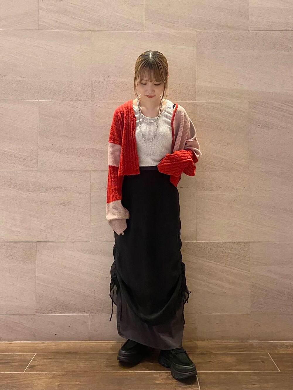 ブラック系のスカート、ブラック系のスニーカー、ベージュ系のタンクトップを着用したレディースの夏コーディネートの2枚目の写真