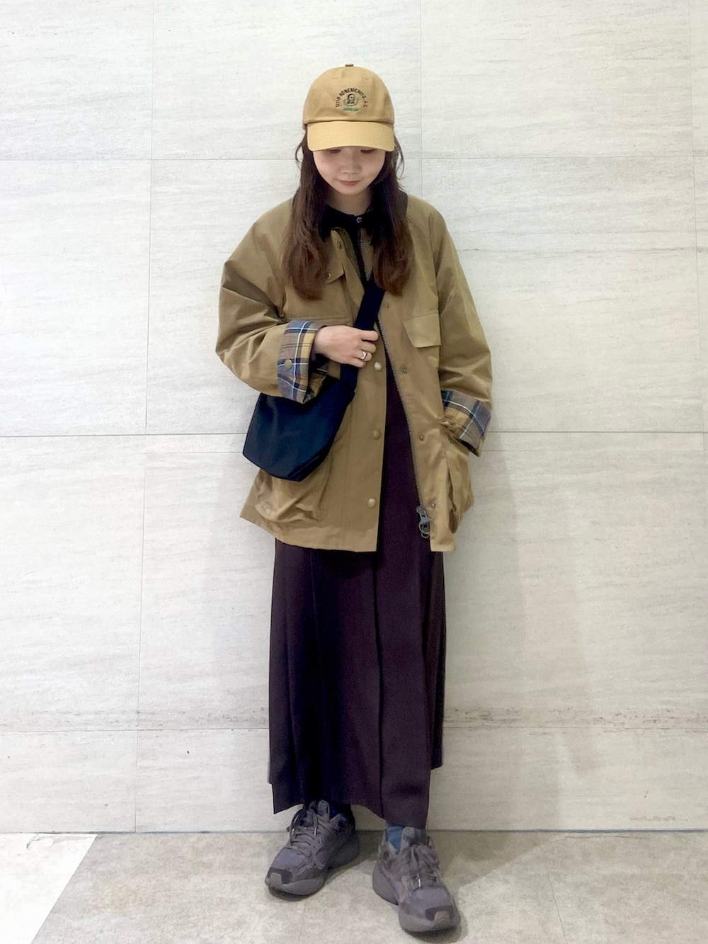 ブラック系のショルダーバッグ、ブラウン系のワンピース、ベージュ系のその他アウターを着用したレディースの秋コーディネートの2枚目の写真